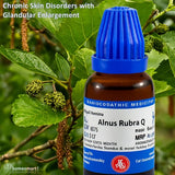 Bottle of Alnus Rubra Q with a blue cap on a green leafy background showing Red Alder (Alnus rubra) plant.