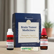 Homeopathic brain tumor medicines with packaging on a wooden surface.