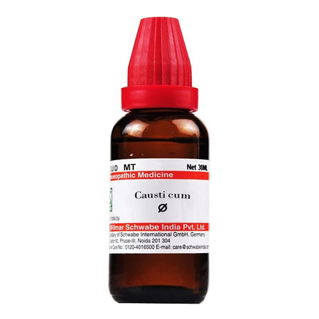 Bottle of Causticum homeopathic medicine with a red cap on a white background
