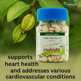 Bottle of Terminalia  Arjuna IX  tablets with green leaves in the background